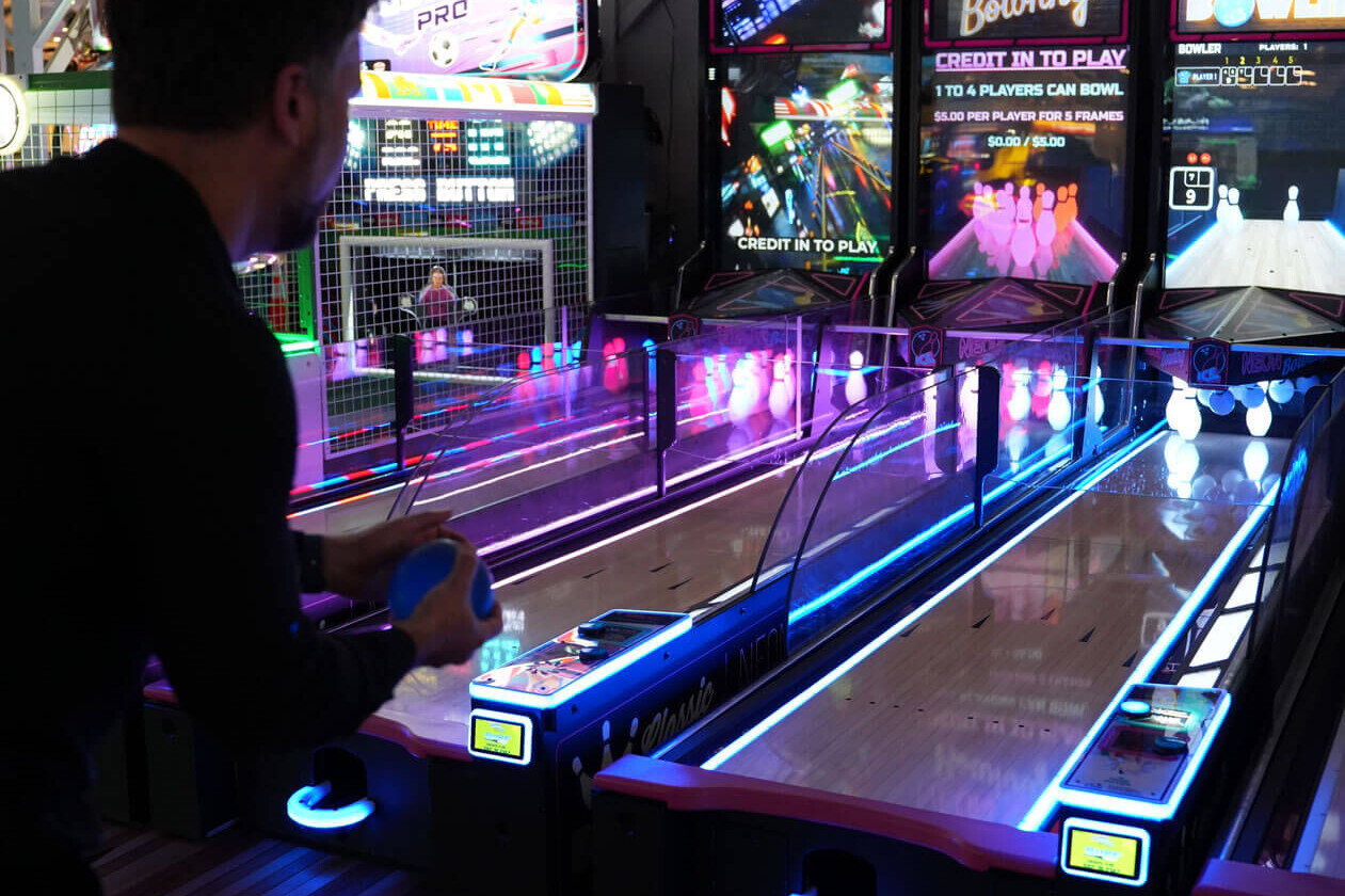 Players rolling on lit-up alley games at the Casino Pier arcade