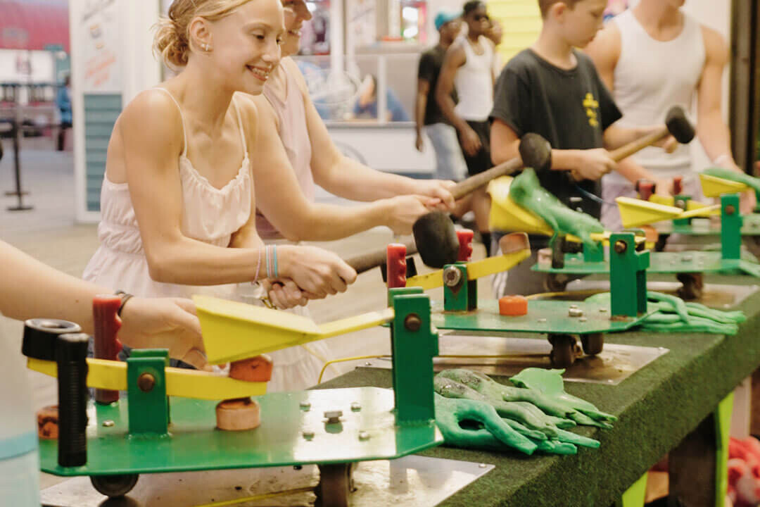 Friends playing a frog launch game on the boardwalk