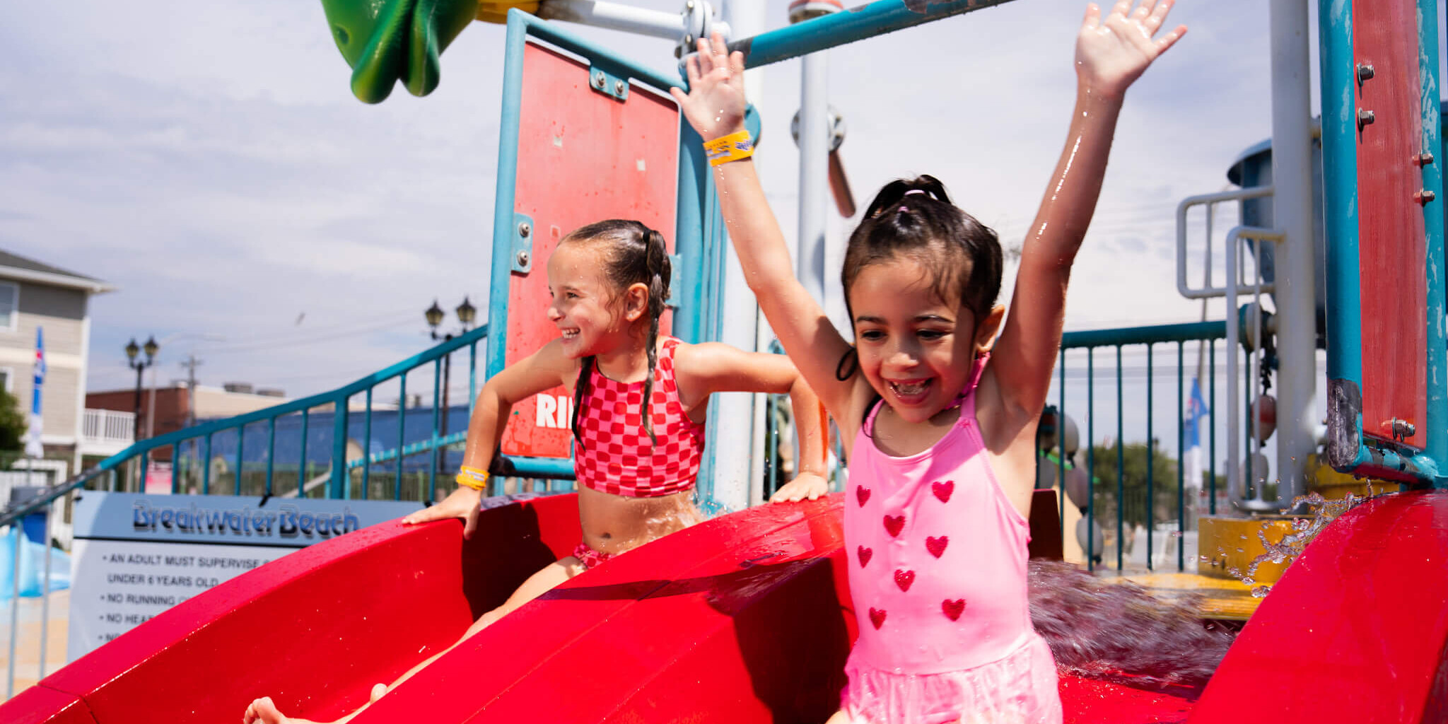 Girl cheering on a waterslide at Breakwater Beach